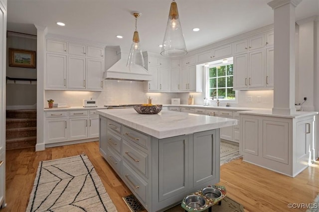 kitchen with custom range hood, gray cabinets, and white cabinets