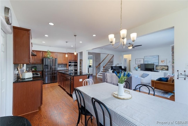 dining space featuring stairway, a notable chandelier, light wood-style floors, and recessed lighting