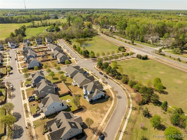 aerial view with a water view, a view of trees, and a residential view