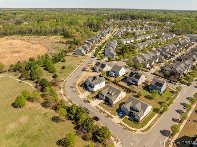drone / aerial view featuring a residential view and a forest view