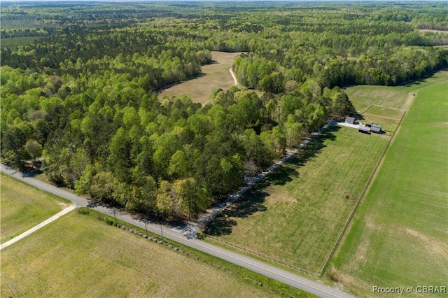 drone / aerial view with a wooded view and a rural view