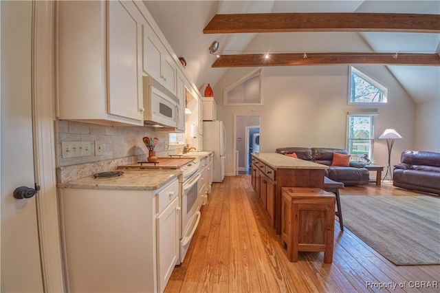 kitchen featuring lofted ceiling with beams, light wood finished floors, white cabinetry, and white appliances