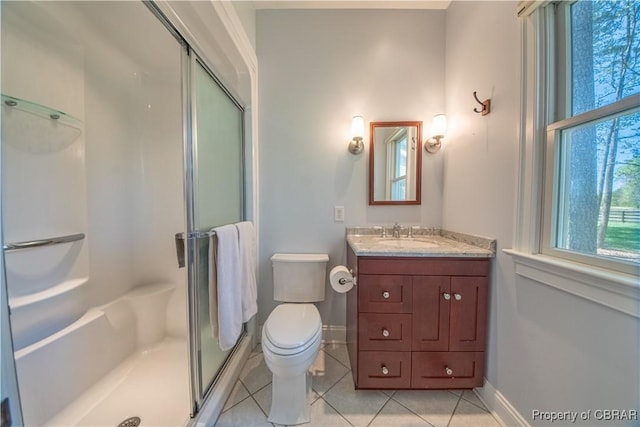 bathroom with a stall shower, tile patterned flooring, and baseboards