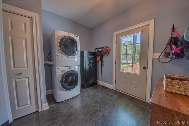 laundry area featuring stacked washer / dryer, laundry area, and baseboards