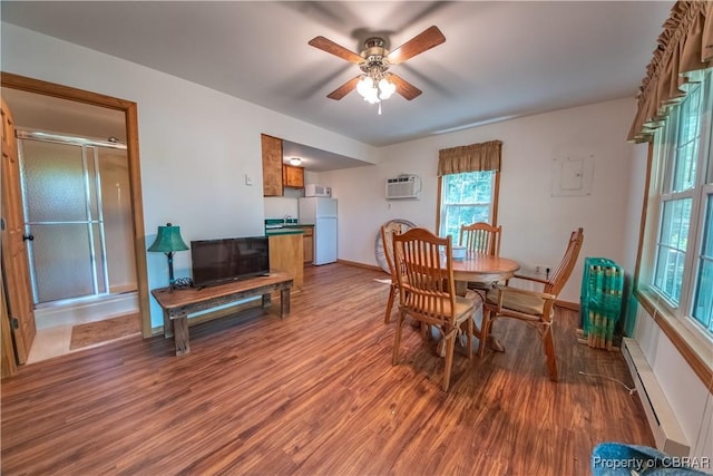 dining space featuring a wall mounted AC, a ceiling fan, baseboards, baseboard heating, and wood finished floors