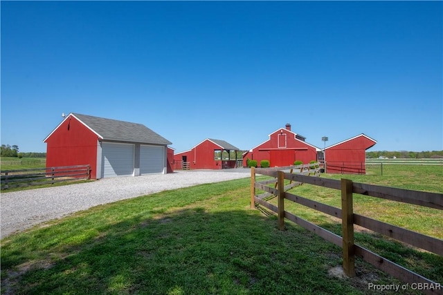 view of yard featuring an outbuilding, a barn, and fence
