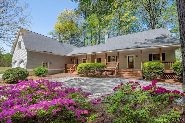 rear view of house featuring a porch and a chimney