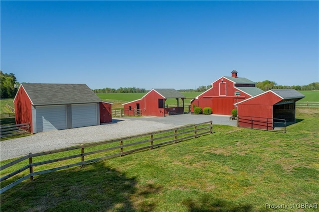 view of yard with an exterior structure, a garage, an outdoor structure, a barn, and fence