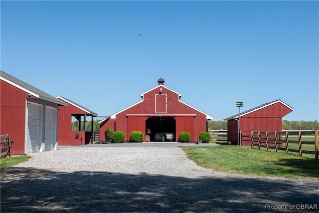 view of barn featuring fence