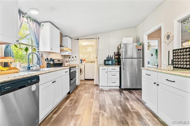 kitchen featuring light wood finished floors, a sink, washing machine and clothes dryer, white cabinetry, and appliances with stainless steel finishes