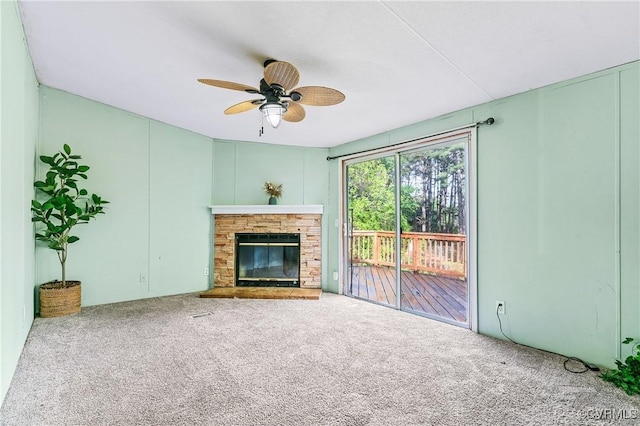 unfurnished living room with a ceiling fan, carpet floors, and a fireplace
