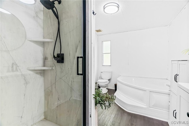 bathroom with toilet, a marble finish shower, a garden tub, and wood finished floors