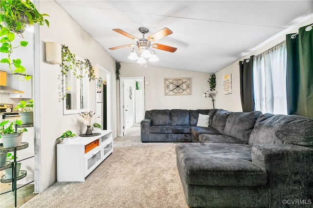 living area with lofted ceiling, ceiling fan, and carpet