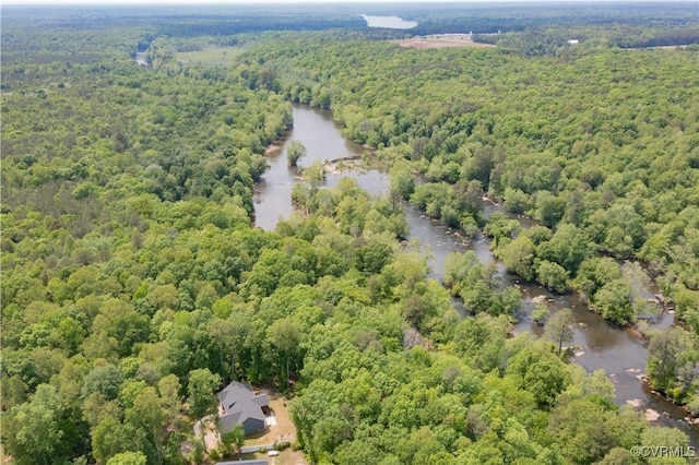 bird's eye view with a water view and a wooded view