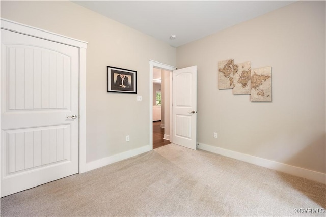 unfurnished bedroom featuring carpet floors and baseboards