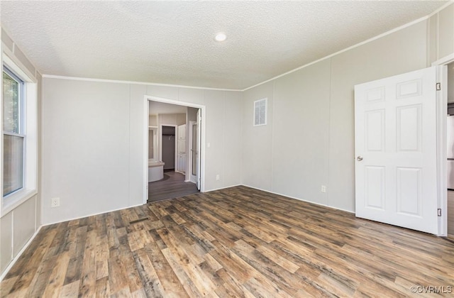 1223 Ullainee Rd, Essex, VA 22436 - empty room featuring crown molding, wood finished floors, a textured ceiling, and a decorative wall
