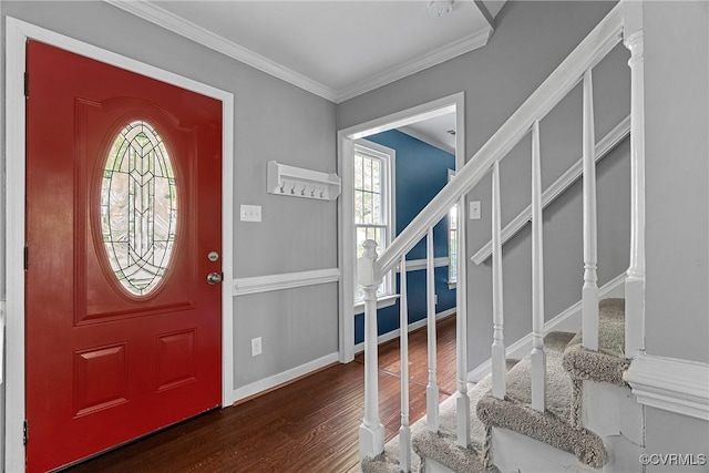 foyer featuring baseboards, ornamental molding, wood finished floors, and stairway