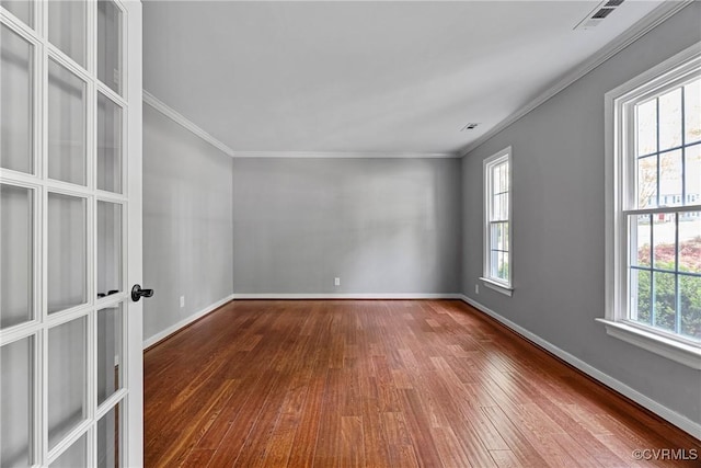 empty room with crown molding, baseboards, and dark wood-style floors
