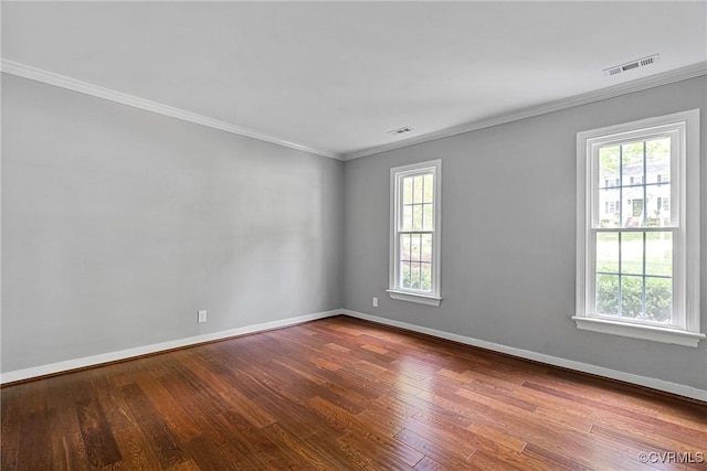 unfurnished room featuring visible vents, a healthy amount of sunlight, and wood finished floors