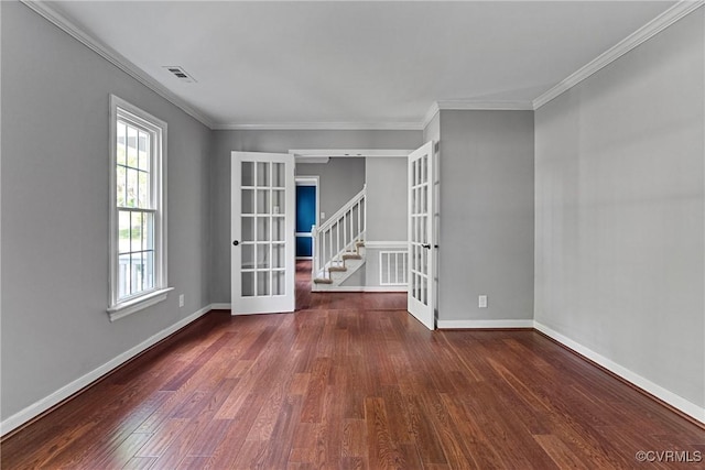 empty room featuring crown molding, visible vents, french doors, and wood finished floors