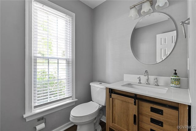 bathroom with toilet, baseboards, and vanity