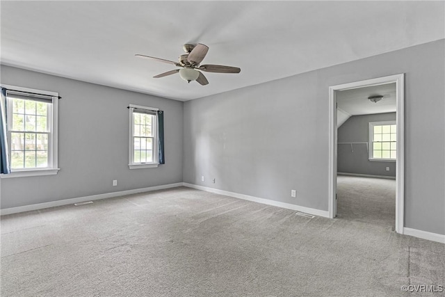 empty room with a ceiling fan, baseboards, a healthy amount of sunlight, and carpet