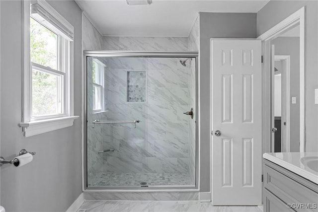 full bathroom with baseboards, a shower stall, and vanity