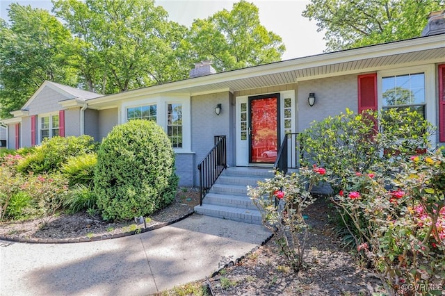 entrance to property featuring a chimney and stucco siding