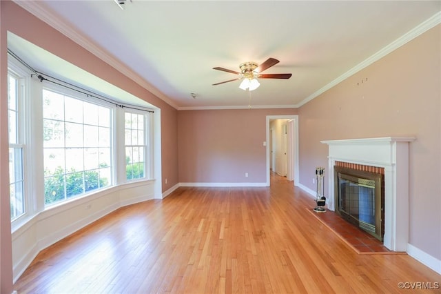 unfurnished living room with a ceiling fan, baseboards, a glass covered fireplace, and light wood-style floors