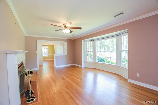 unfurnished living room with a healthy amount of sunlight, light wood-style floors, a ceiling fan, and visible vents