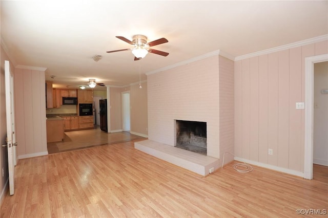 unfurnished living room with crown molding, ceiling fan, a fireplace, light wood-style floors, and baseboards