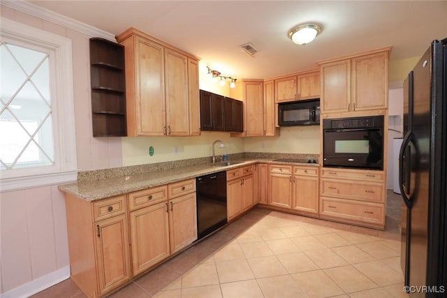 kitchen featuring a sink, light brown cabinetry, black appliances, and a wealth of natural light