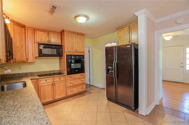 kitchen with light tile patterned flooring, a sink, baseboards, visible vents, and black appliances