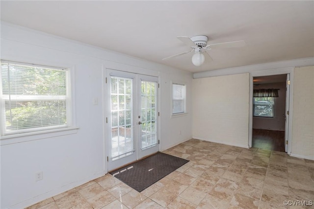 doorway featuring stone finish floor, plenty of natural light, french doors, and ceiling fan