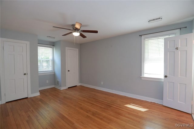 unfurnished bedroom with visible vents, a ceiling fan, light wood finished floors, and baseboards