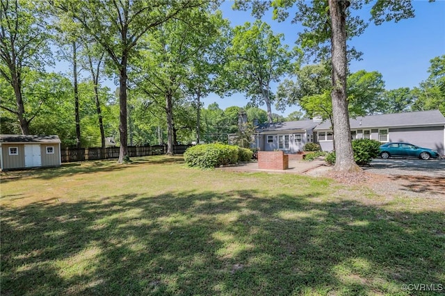 view of yard with a storage shed, fence, and an outdoor structure
