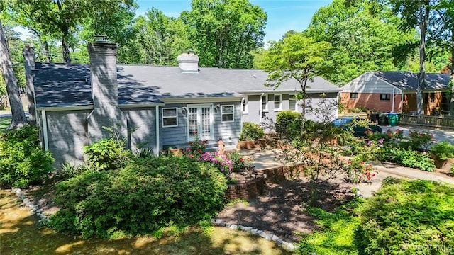 rear view of property with french doors and a chimney