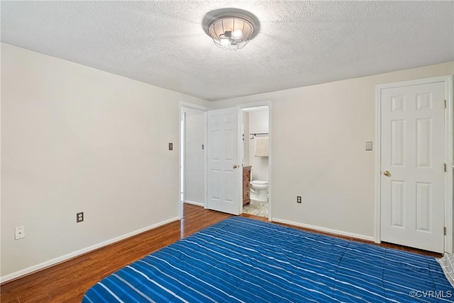 3218 Matilda Cv Unit 104, Henrico, VA 23294 - unfurnished bedroom with wood finished floors, baseboards, a textured ceiling, and ensuite bath