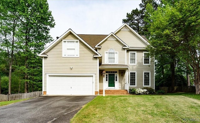 traditional home featuring a garage, fence, driveway, and a front yard