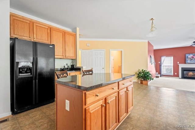 156 Hawk Nest Ct, Richmond, VA 23227 - kitchen featuring black fridge, a kitchen island, open floor plan, a glass covered fireplace, and ornamental molding