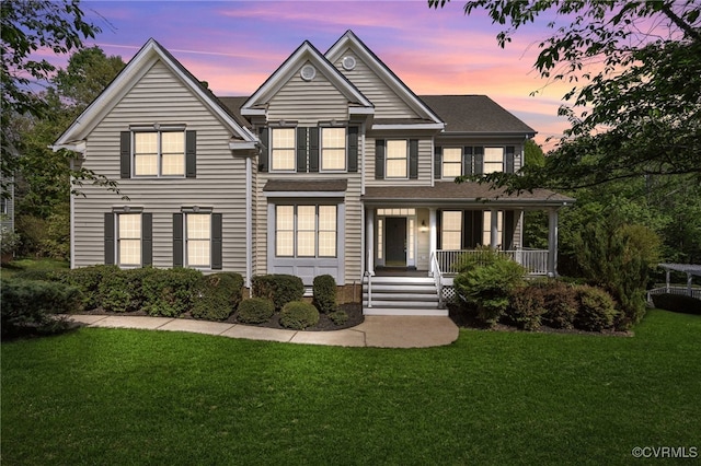 traditional-style home featuring a lawn and covered porch