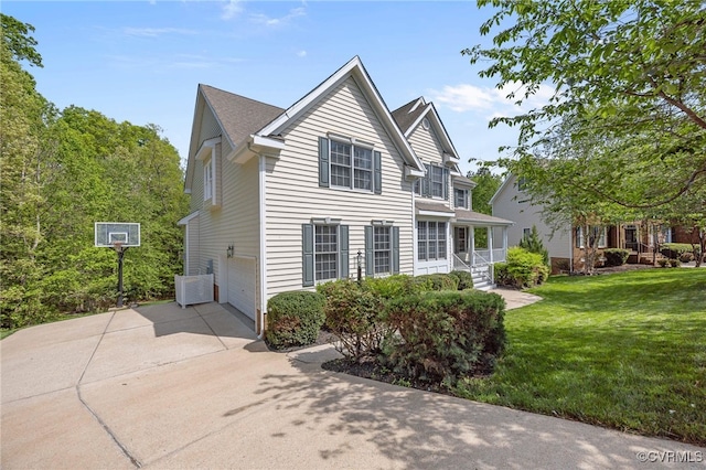 view of side of property featuring driveway, a yard, and an attached garage