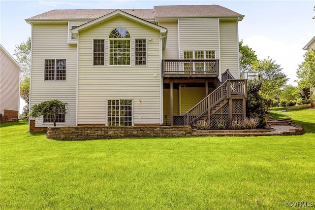back of property with a deck, a yard, and stairs