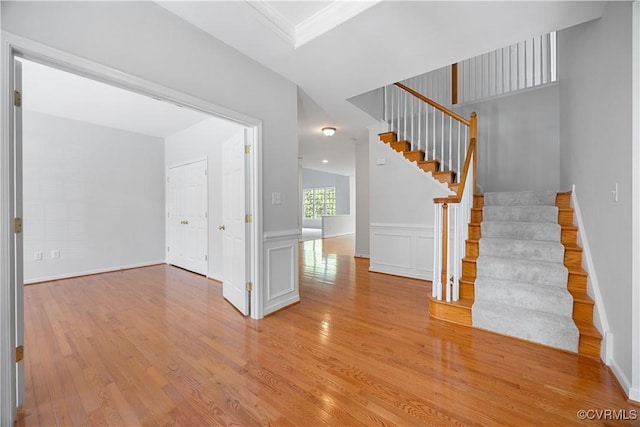 interior space featuring a wainscoted wall, stairs, and wood finished floors