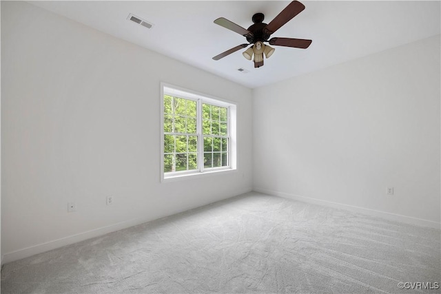 carpeted spare room with visible vents, ceiling fan, and baseboards