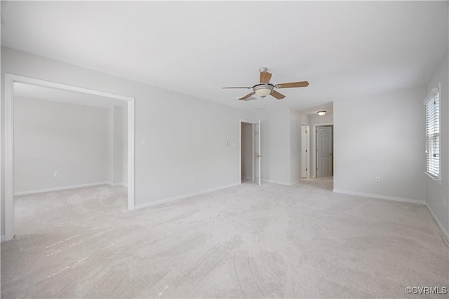 empty room with baseboards, light carpet, and a ceiling fan