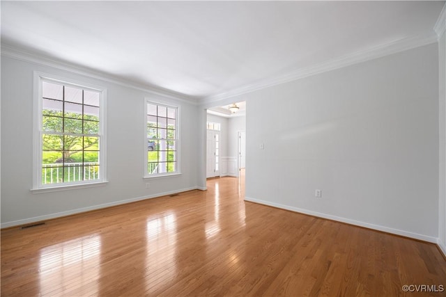 unfurnished room with visible vents, light wood-style floors, ornamental molding, and baseboards