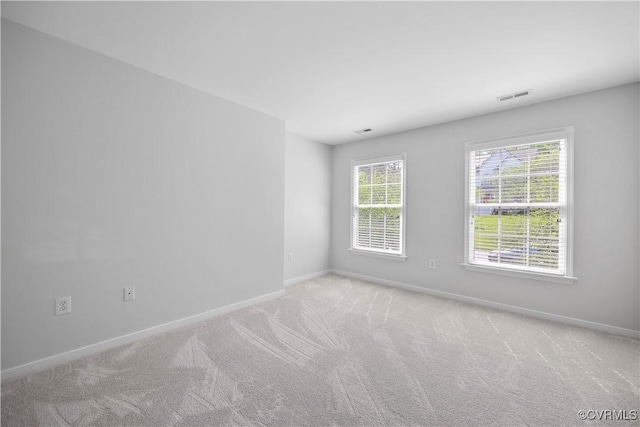 unfurnished room with baseboards, visible vents, and carpet