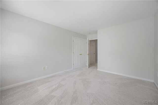empty room with light colored carpet and baseboards