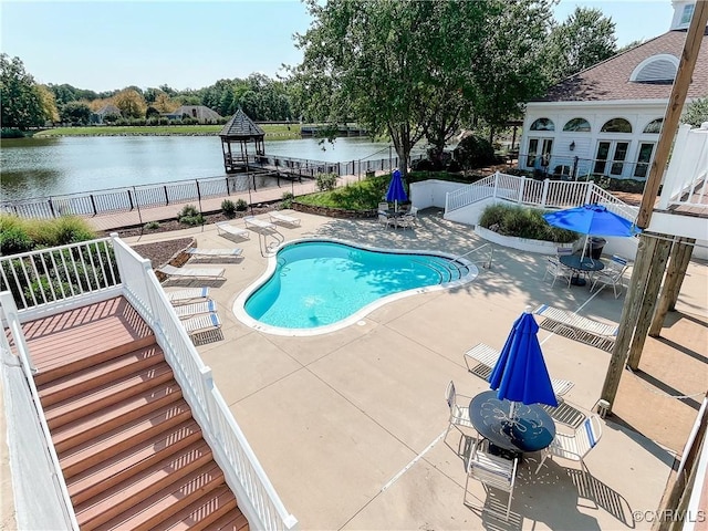 community pool featuring a fenced backyard, a patio, a water view, and a gazebo